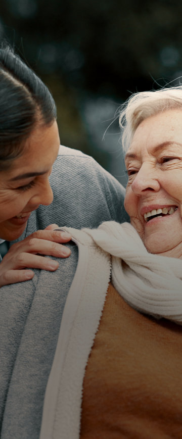 A woman and an elderly woman smiling