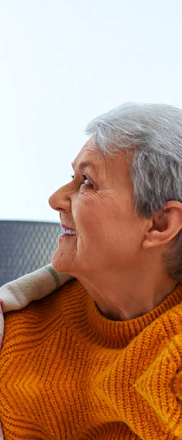 A nurse giving water to an elderly woman