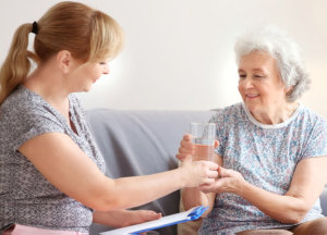 A nurse combing the hair of the elderly woman