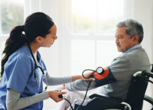 A nurse monitoring an old man