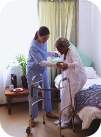 A nurse assisting an elderly woman to stand up