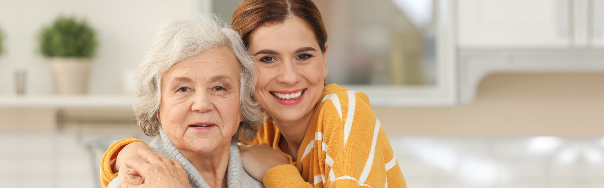 An elderly woman with a smiling woman