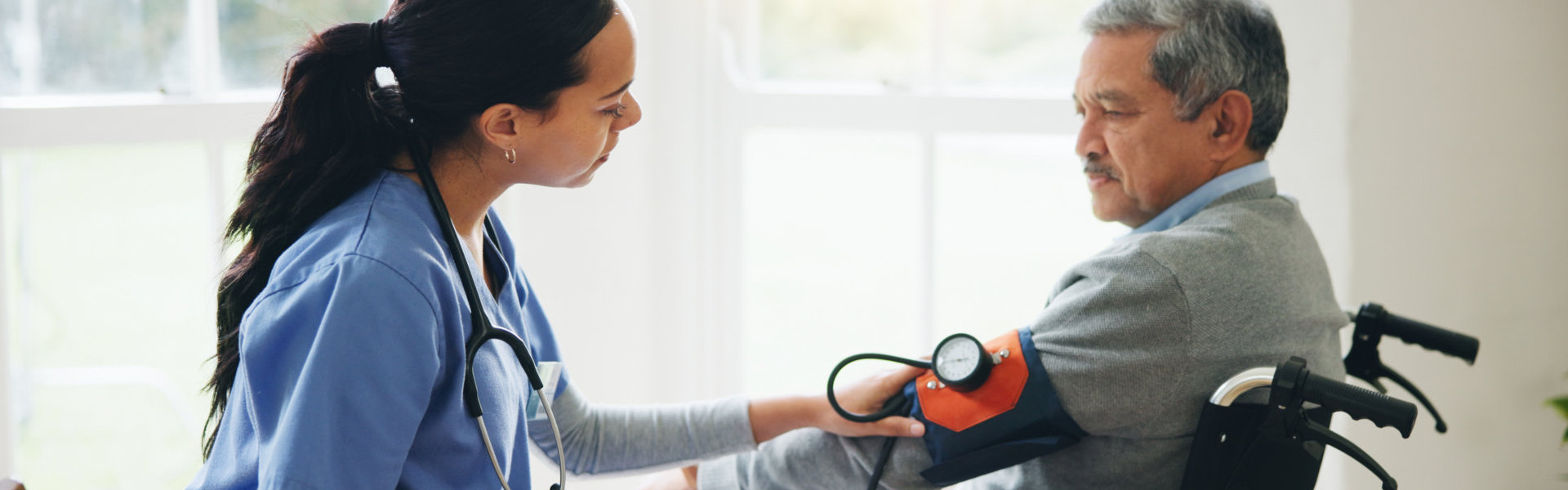 A nurse monitoring an old man